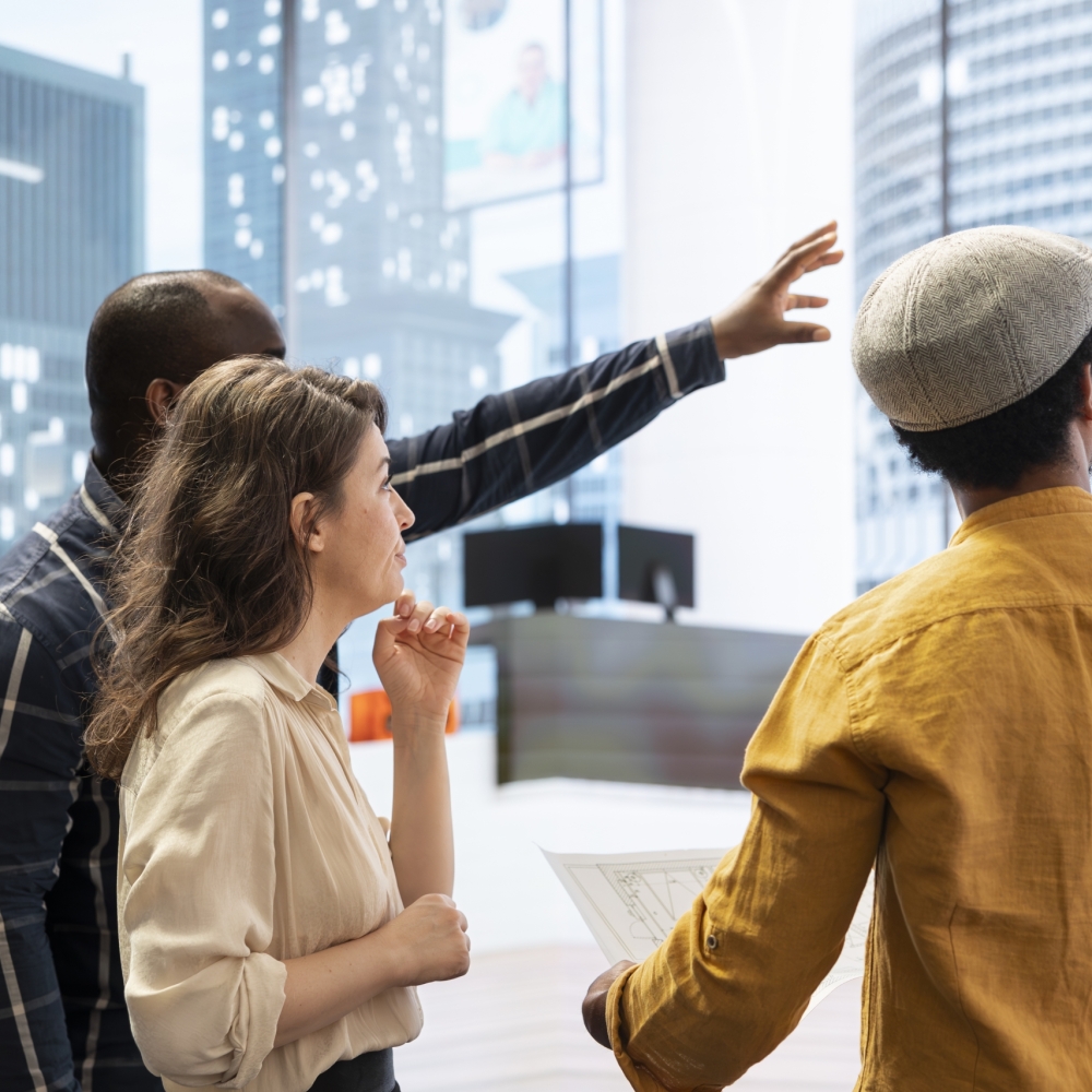 Realtor and clients sharing workspace design vision on an office tour, evaluating modern property layout and blueprints before moving to a high class urban setting. Leasing contract negotiation.